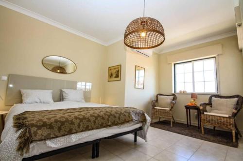 ein Schlafzimmer mit einem großen Bett und einem Stuhl in der Unterkunft Townhouse w Beautiful terrace - 360 degrees views! in Lagos