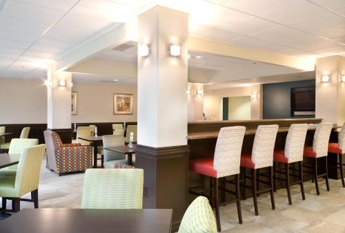 a restaurant with tables and chairs and a bar at Holiday Inn Express Hotel and Suites Brownsville by IHG in Brownsville