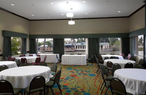 a conference room with tables and chairs and windows at Holiday Inn Express Hotel and Suites Brownsville by IHG in Brownsville