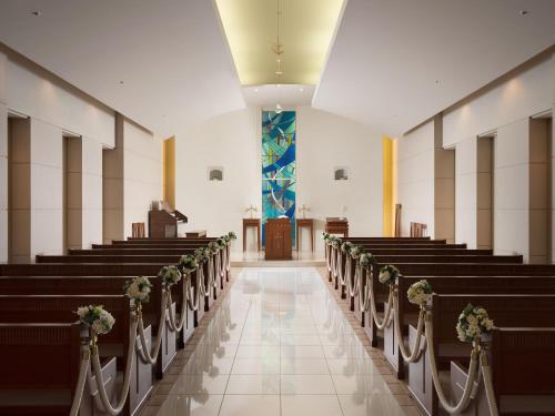 a church aisle with rows of pews with flowers at ANA Crowne Plaza Chitose by IHG in Chitose
