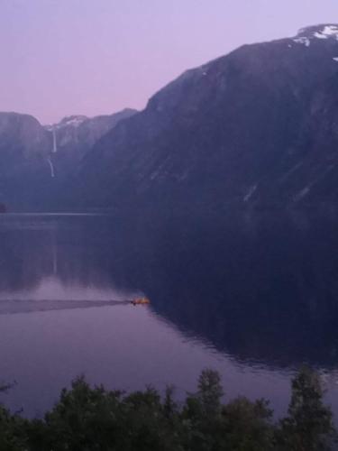 uma grande massa de água com montanhas ao fundo em Iris Vedal em Nauste