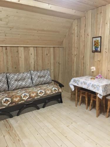 a room with two tables and a couch in a cabin at Володар in Yaremche