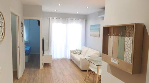 sala de estar con sofá blanco y mesa en Apartamento Blanes, en Blanes