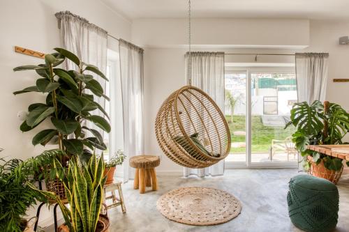 a room with potted plants and a swing at Selina Boavista Ericeira in Ericeira