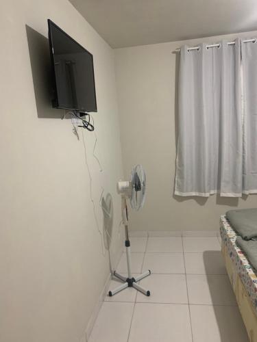 a room with a fan and a television on a wall at Pousada Serra Carioca Friburgo in Nova Friburgo