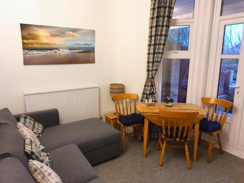 a living room with a couch and a table at Summerhill Apartments in Shanklin