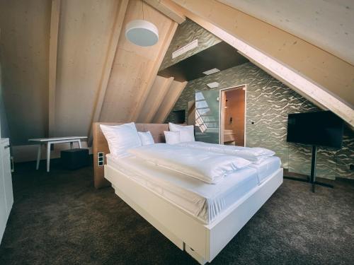 ein Schlafzimmer mit einem großen Bett im Dachgeschoss in der Unterkunft Stadthotel Haslach in Haslach im Kinzigtal