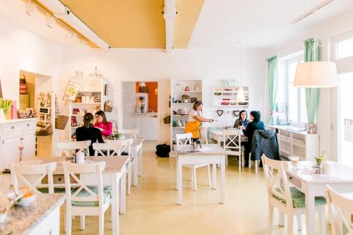 a group of people sitting at tables in a restaurant at Domizil Gols, Studios Am Anger in Gols