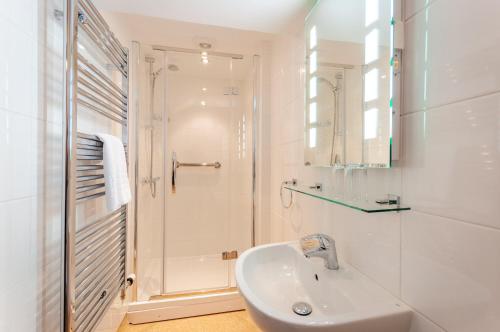 a white bathroom with a sink and a shower at Baron at Bucknell in Bucknell