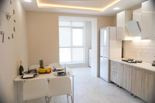 una cucina con tavolo, sedie e frigorifero di Просторная однокомнатная ЖК Счастливый a Dnipro