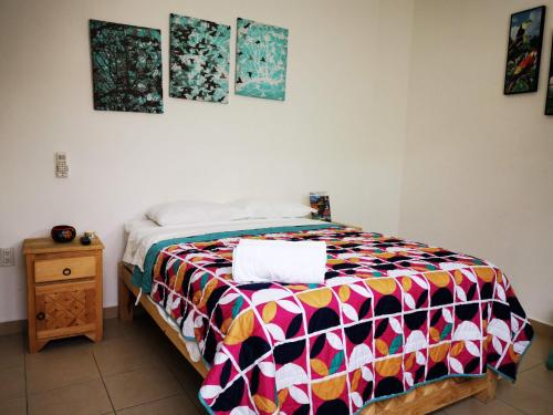 a bedroom with a bed with a colorful comforter at Terraza Sancris in Tuxtla Gutiérrez