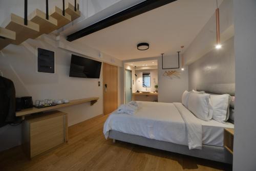 a bedroom with a white bed and a television at A.P. Acropolis View Apartments in Athens