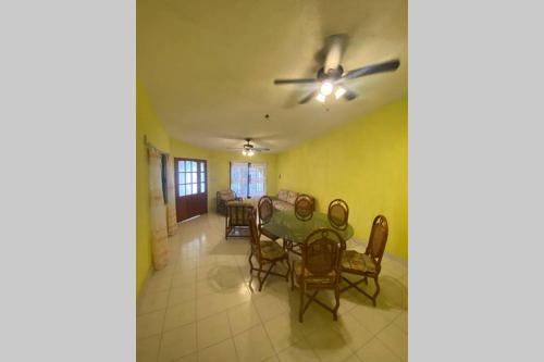 ein Esszimmer mit einem Tisch und Stühlen sowie einem Deckenventilator in der Unterkunft Casa Colonial in Campeche