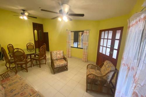 ein Wohnzimmer mit einem Deckenventilator und Stühlen in der Unterkunft Casa Colonial in Campeche
