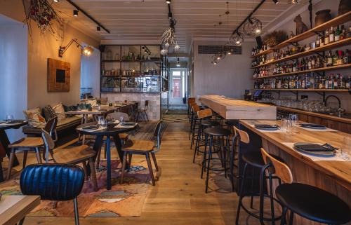 a restaurant with tables and chairs and a bar at Amymone Suites in Nafplio