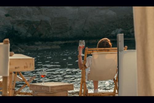 a woman sitting in a chair holding a glass of wine at AQUA HOUSE in Pachaina
