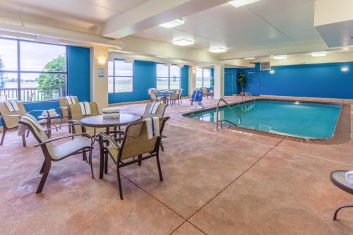 - une piscine dans une chambre d'hôtel dotée de tables, de chaises et d'une table dans l'établissement Holiday Inn Express Hotel & Suites Bowling Green, an IHG Hotel, à Bowling Green