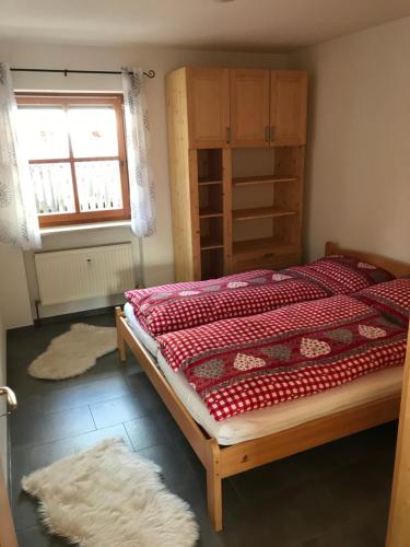 a bedroom with a bed and a window and a rug at Ferienwohnung Magdalena in Bodenmais