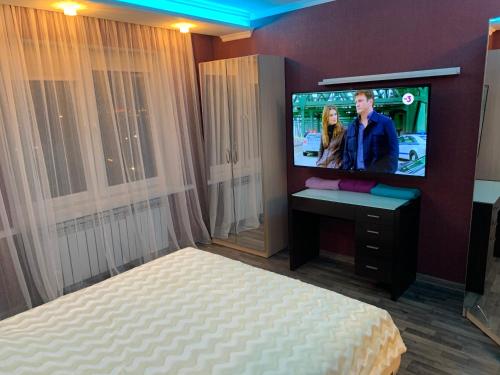 a bedroom with a bed and a flat screen tv at Amber Apartments in Kaliningrad