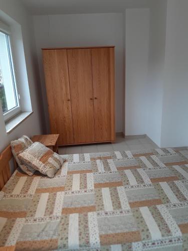 a bedroom with a bed and a wooden cabinet at Maris Pokoje Gościnne in Łeba