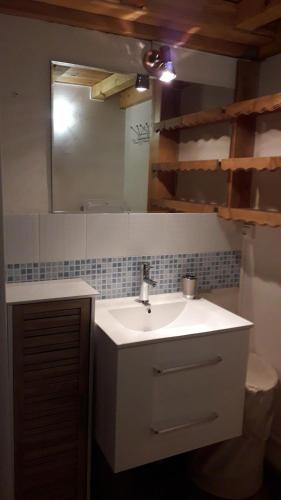 une salle de bain avec un lavabo, des toilettes et un miroir dans l'établissement joli T3 proche centre et télécabines, à Saint-Gervais-les-Bains