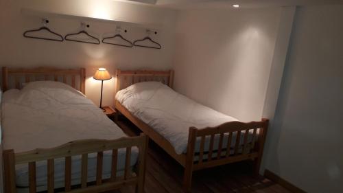 - 2 lits jumeaux dans une chambre avec une lampe dans l'établissement joli T3 proche centre et télécabines, à Saint-Gervais-les-Bains
