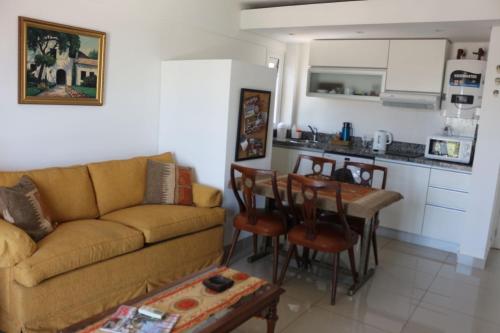 sala de estar con sofá, mesa y cocina en Departamento nuevo y luminoso en el centro. en La Rioja