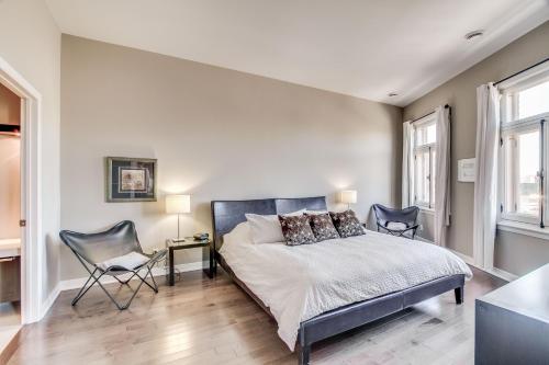 a bedroom with a bed and a desk and two chairs at The Palace Condo by BnbCopilote in Quebec City