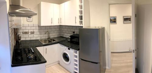 a kitchen with a refrigerator and a washing machine at Maryport House in Maryport