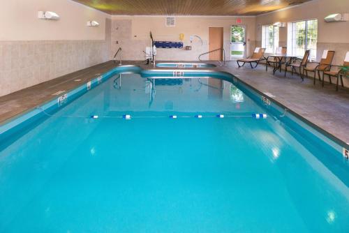 a swimming pool in a hotel with blue water at Holiday Inn Express & Suites Bucyrus by IHG in Bucyrus