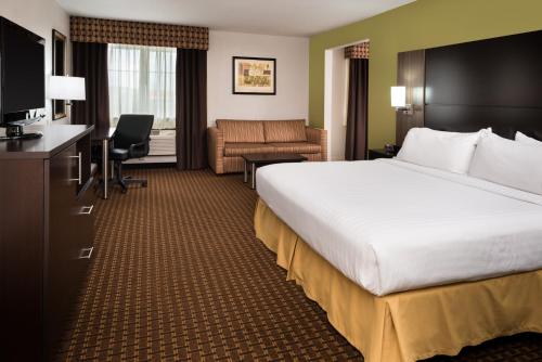 a hotel room with a large bed and a desk at Holiday Inn Express Hotel & Suites Bucyrus, an IHG Hotel in Bucyrus