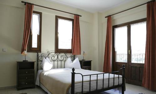 a bedroom with a bed and two windows at Guesthouse Mirihos in Vlásti