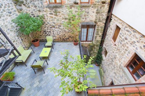 an outdoor patio with tables and chairs and a building at Gredo Antica Dimora in Villafranca in Lunigiana