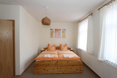 ein Schlafzimmer mit einem Bett mit einem Bettrahmen aus Holz in der Unterkunft Pension Thaler Hof in Thale