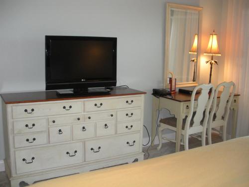 1 dormitorio con tocador y TV encima. en Villas Of Amelia Island, en Amelia Island