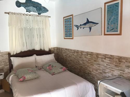 a bedroom with a bed with a fish on the wall at Pousada Mercador in Paraty
