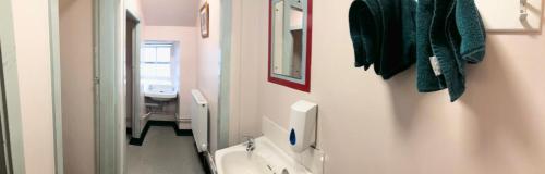 a bathroom with a toilet, sink, and mirror at High Street Hostel in Edinburgh