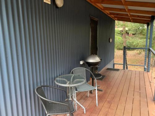 a patio with two chairs and a table and a grill at The Lodges Two in Halls Gap