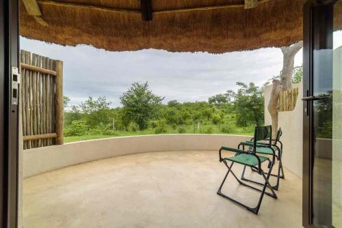 a patio with two chairs and a window at Lengau Lodge in Grietjie Nature Reserve