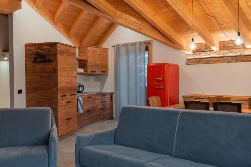 un soggiorno con divano blu e frigorifero rosso di Pista Stelvio Loft Lumière a Bormio