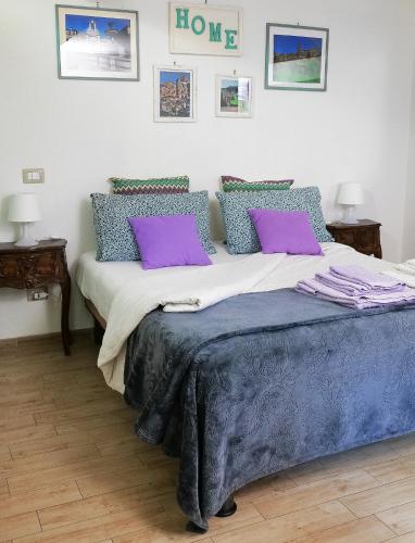 una camera da letto con un grande letto con cuscini viola di Casa vacanza LA MIA CASETTA SUTRI a Sutri