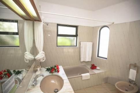 a bathroom with a tub and a sink and a bath tub at Casa Carioca in Benagil