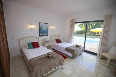two beds in a room with a view of a pool at Casa Carioca in Benagil