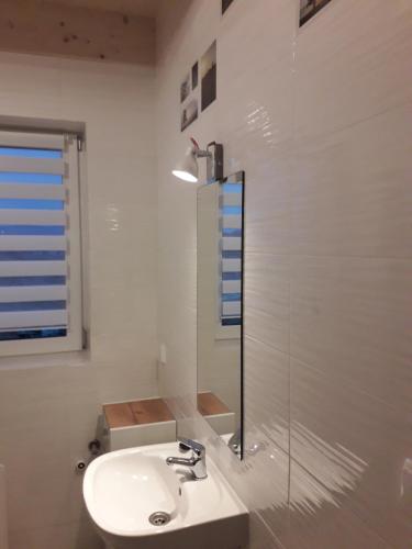 a white bathroom with a sink and a shower at Domek do wynajęcia SkoSki in Jaworzynka