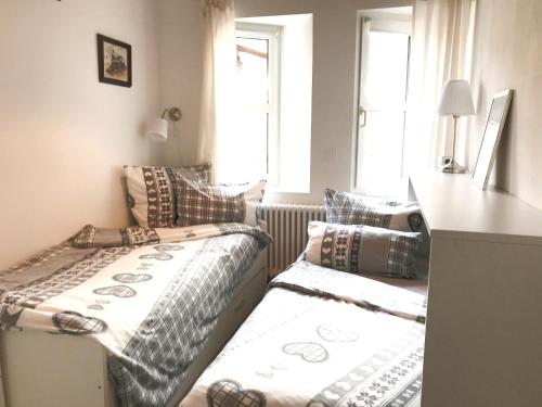 two beds in a small room with a window at Holiday @ Bad Hindelang in Bad Hindelang