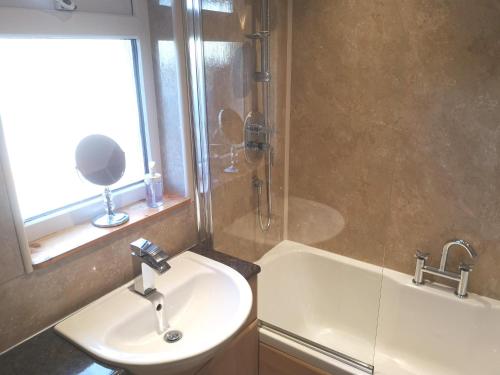 a bathroom with a sink and a shower at Highland Home From Home in Inverness