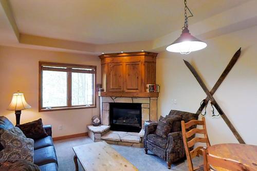 a living room with a fireplace and a table at Romance at Riverbends' Snowflake Lift in Breckenridge