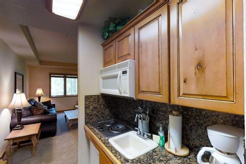 a kitchen with a sink and a microwave at Romance at Riverbends' Snowflake Lift in Breckenridge