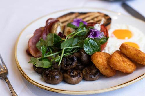 a plate of breakfast food with eggs and mushrooms at The Sebel Quay West Suites Sydney in Sydney