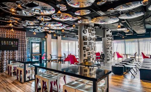 a restaurant with tables and chairs and a ceiling at Lorenzo Hotel Dallas, Tapestry Collection by Hilton in Dallas
